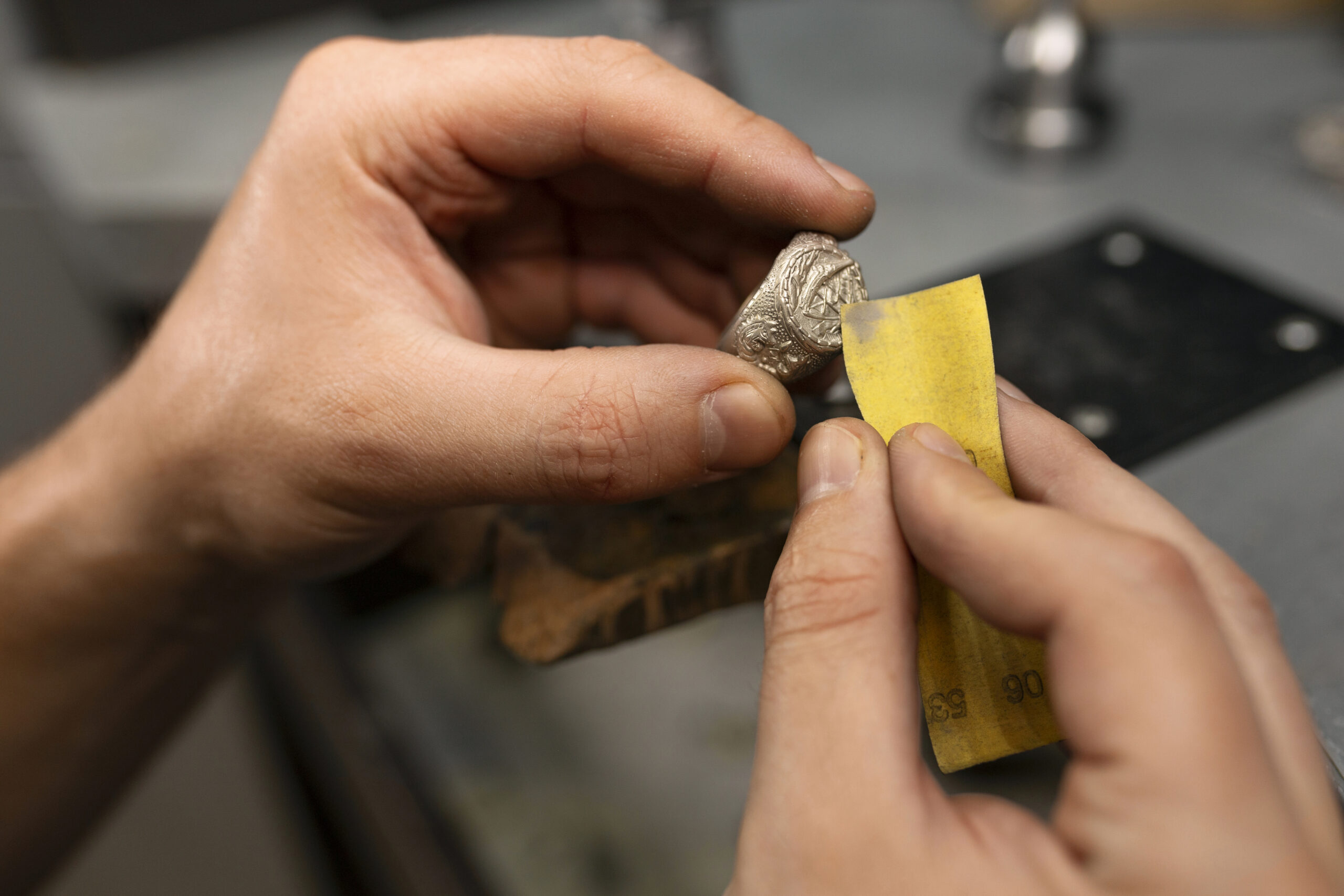 Goldschmied bei der Schmuckbearbeitung – präzise Handarbeit in der Werkstatt.